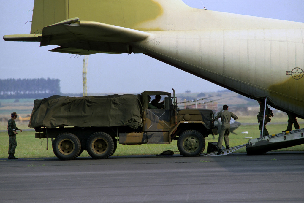 M35 cargo truck is offloaded from a C-130 Hercules airlift during excercise REFORGER '83